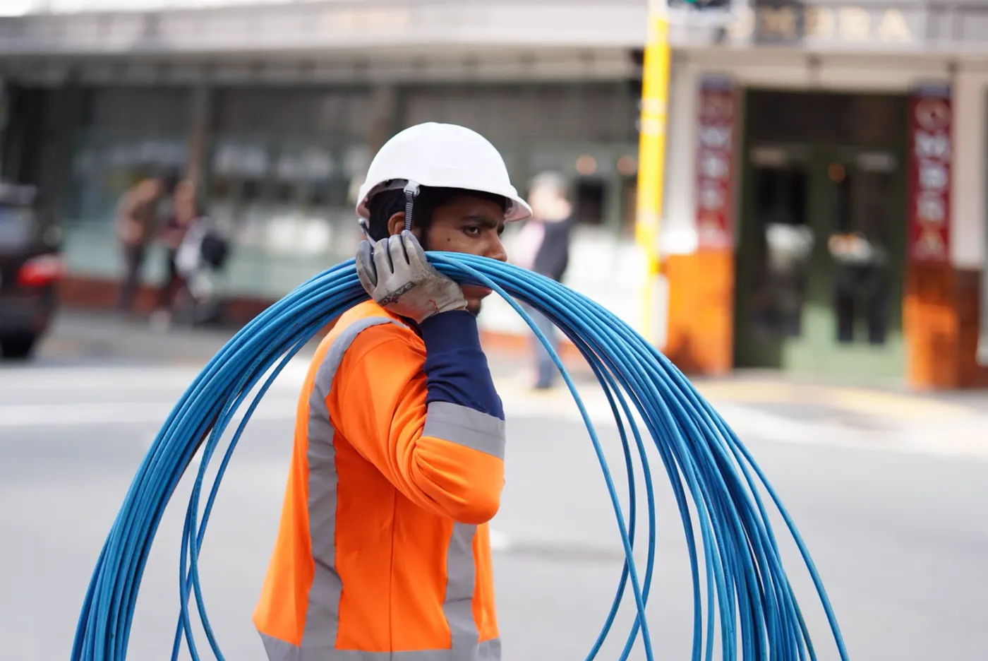 Técnico cargando un rollo de cable de red en la calle